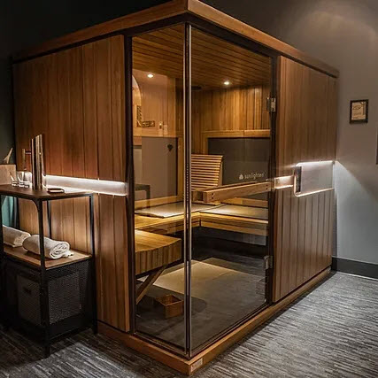 Outside view of infrared sauna made of wood with a glass door.