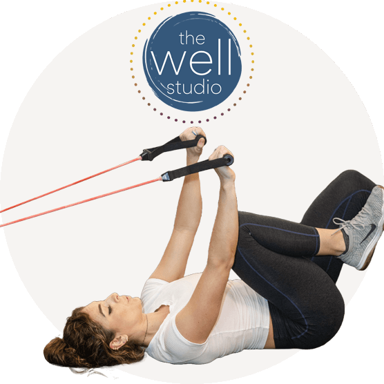 Person laying on back with arms in straps pulling weights while looking up at Well Studio logo.