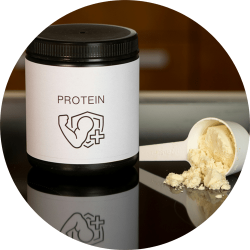 A jar of protein powder on a table with a measuring scoop full of powder next to it.