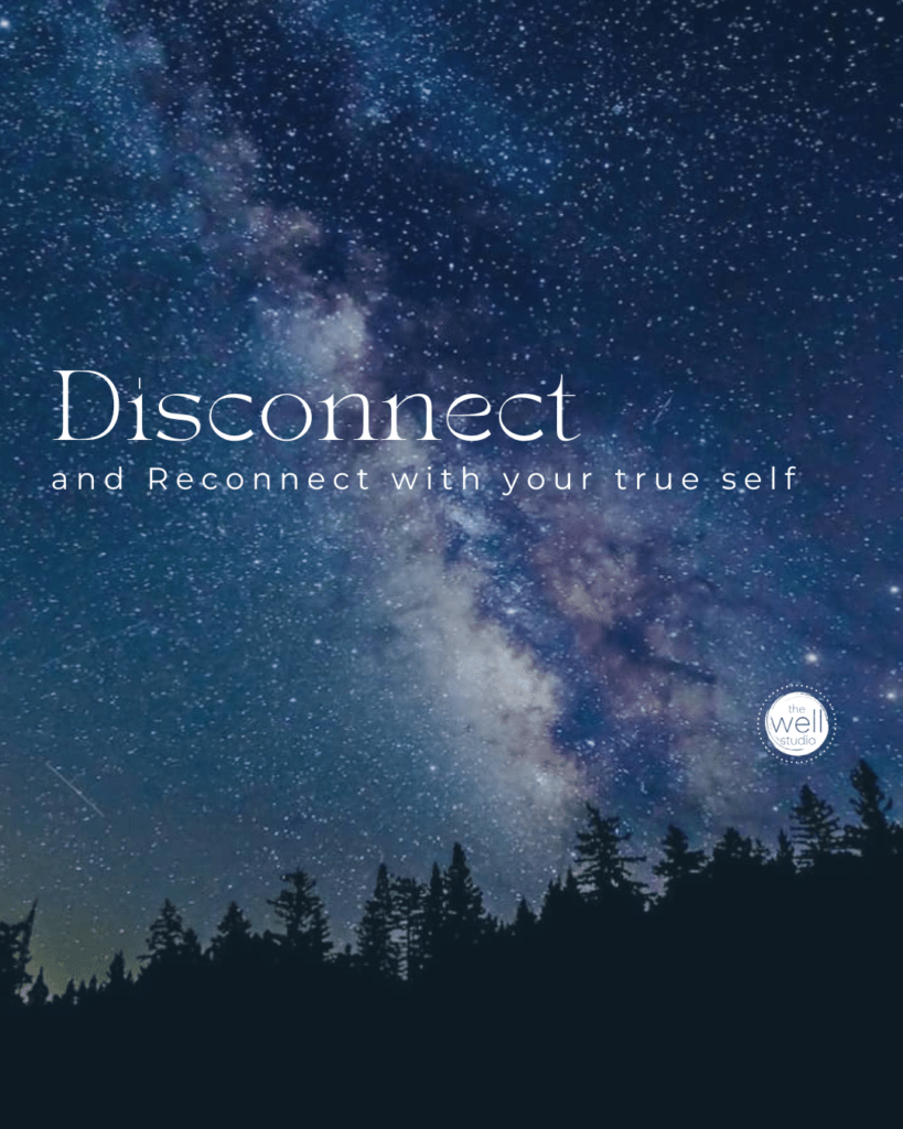 The milky way against a dark blue sky above a mountain with text overlay "Disconnect to reconnect with your true self"