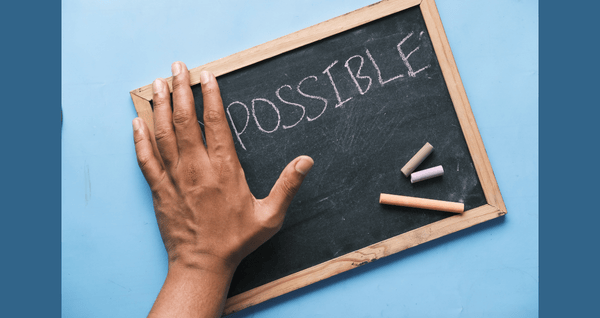 chalk board with the word impossible and a hand over the "im" with focus on what's possible!